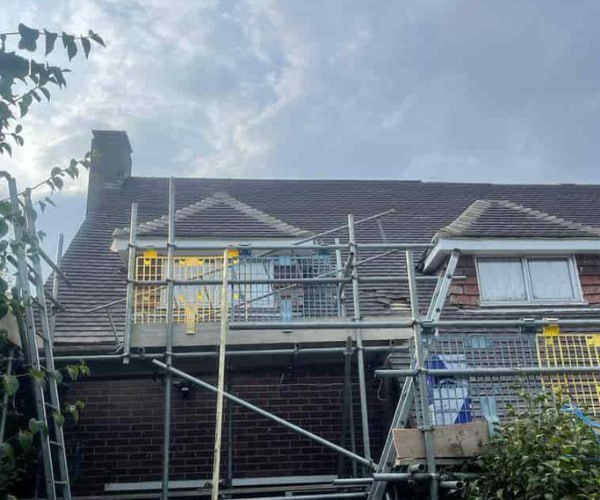 This is a photo of a roof with two dormers that is having some damaged tiles replaced. Works carried out by EA Roofing Daventry